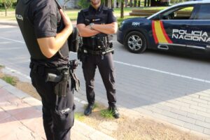 agentes de la Policía Nacional cerca de su coche patrulla